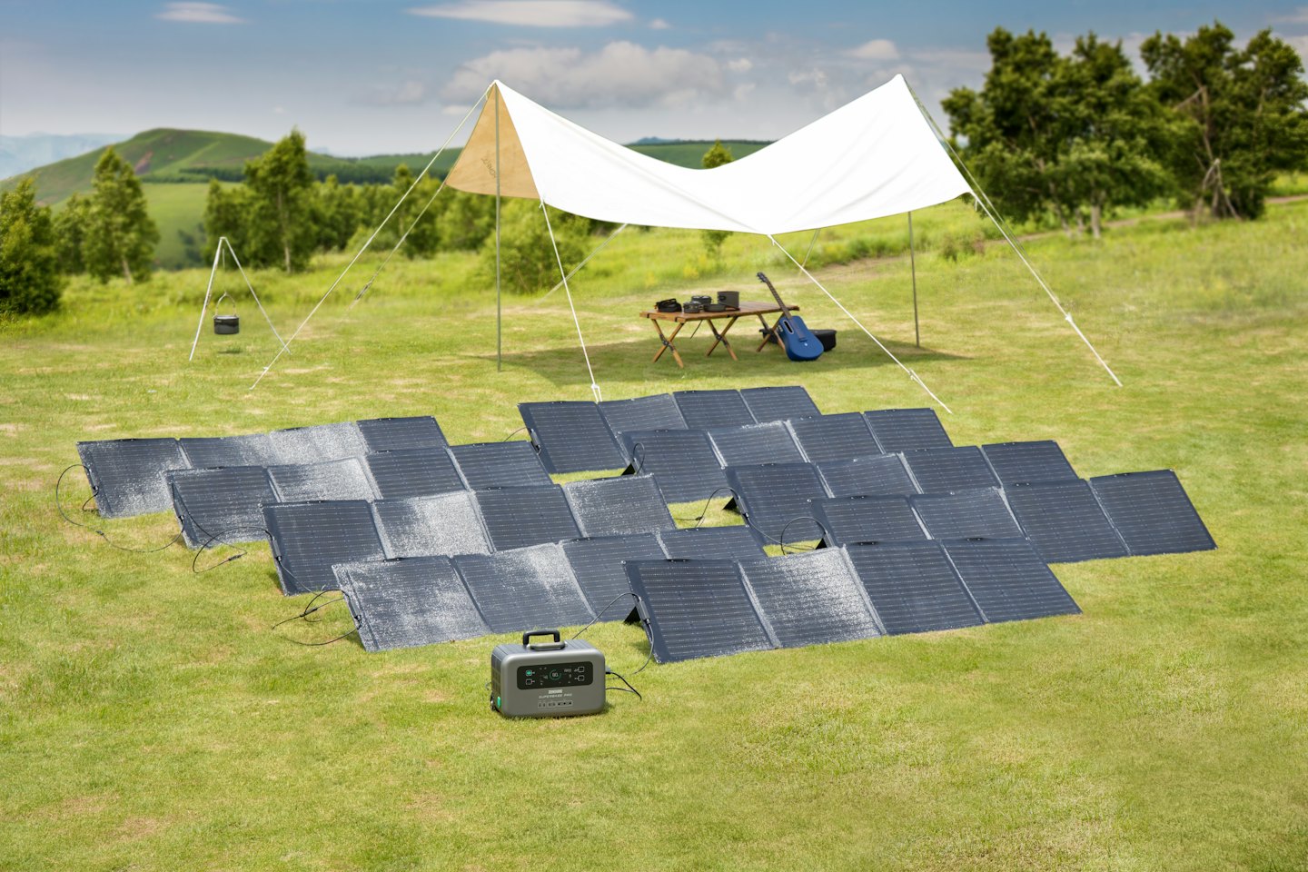 Portable solar panels connected to a power station in a grassy field.